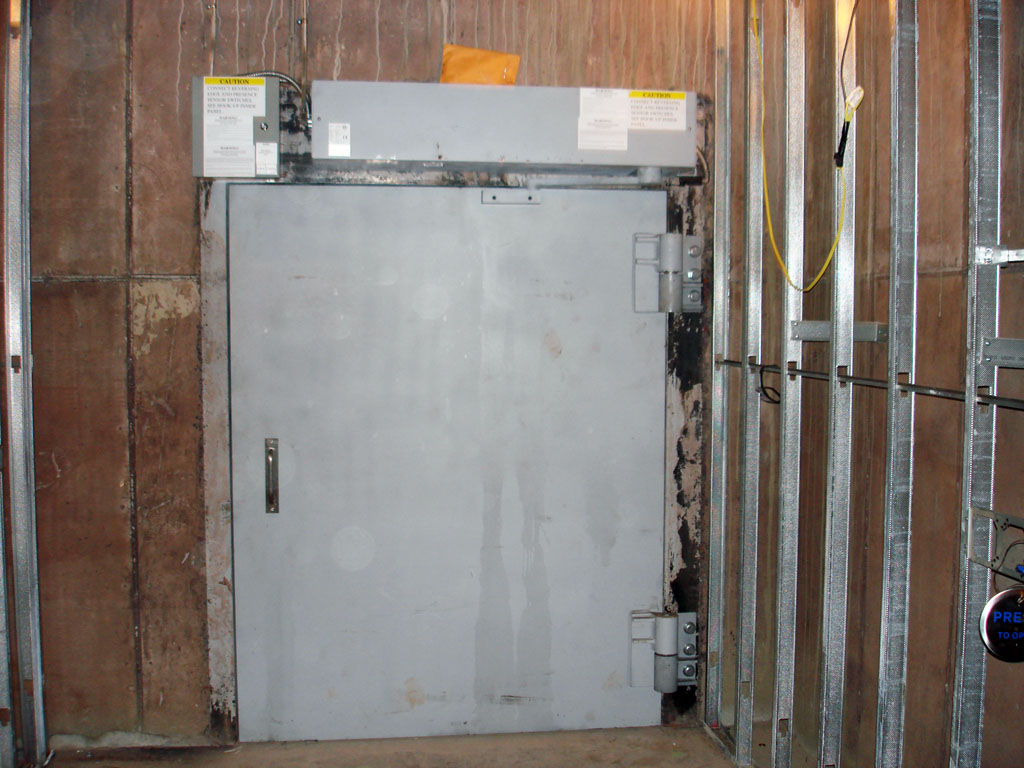 Wide neutron door installed and standing open at a treatment vault entrance